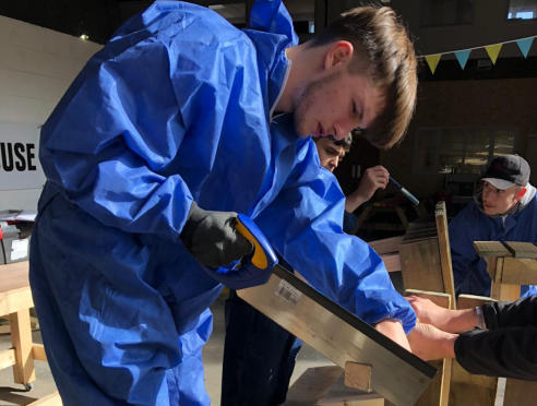 young person takes part in woodwork session at boiler house, moss side, manchester